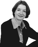 Ein Teammitglied mit kurzen Haaren, Kragenhemd und Blazer sitzt da und lächelt in die Kamera. Das Bild ist in Schwarz-Weiß gehalten und hat einen einfachen weißen Hintergrund.