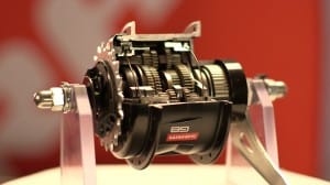 Eine Schnittansicht einer SRAM G8-Nabe mit interner Fahrradschaltung ist auf einem Ständer montiert und zeigt die komplizierten Zahnräder und internen Mechanismen im Inneren des schwarzen Gehäuses.